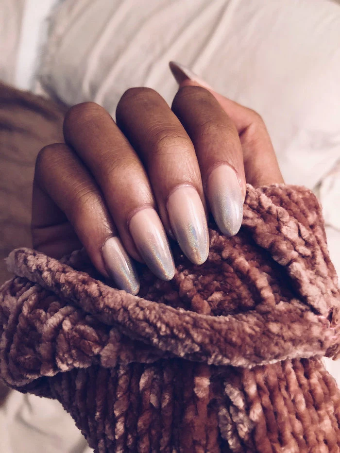 nude to metallic silver gradient nail polish, ombre coffin nails, long almond nails, hand covered with knitted velvet sleeve