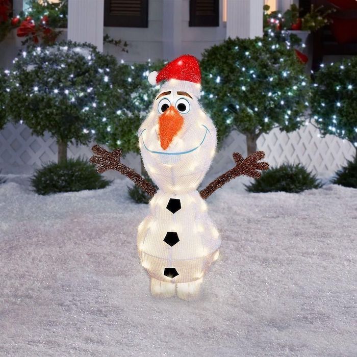 olaf from frozen, figurine with lights inside, christmas deer decorations, placed in the snow, bushes with lights in the background