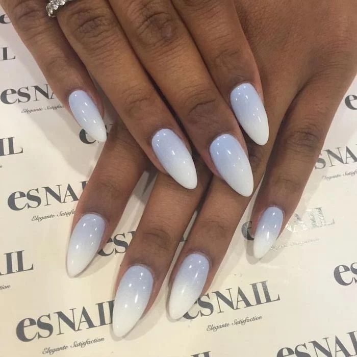 icy blue to white gradient nail polish, red ombre nails, long almond nails, hands placed on white surface