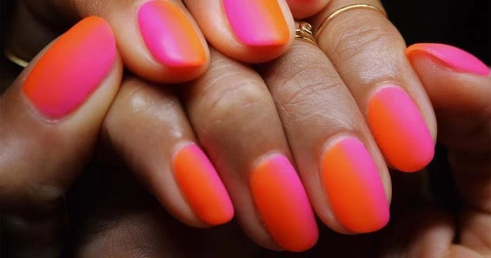orange to pink vertical gradient matte nail polish, short squoval nails, golden rings on the fingers, french tip acrylic nails