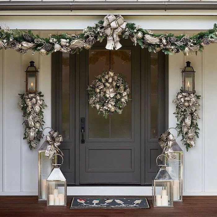 wreaths decorated with gold ribbons, hanging over door and door frame, christmas deer decorations, lanterns on both sides