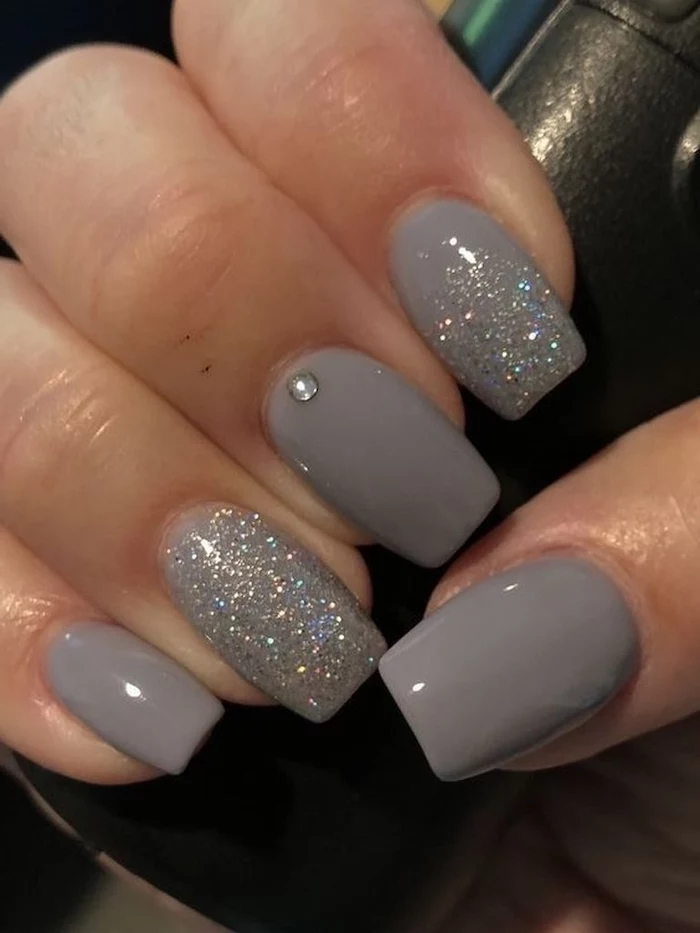 grey nail polish, silver glitter on index and ring finger, popular nail colors, medium length squoval nails