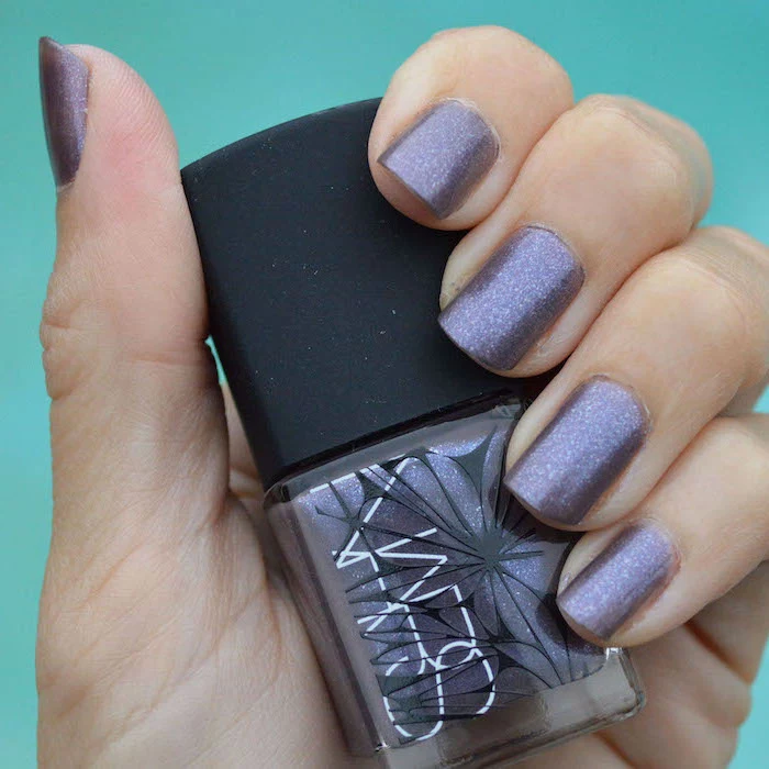 hand holding a nail polish bottle, popular nail colors, purple glitter nail polish, short squoval nails