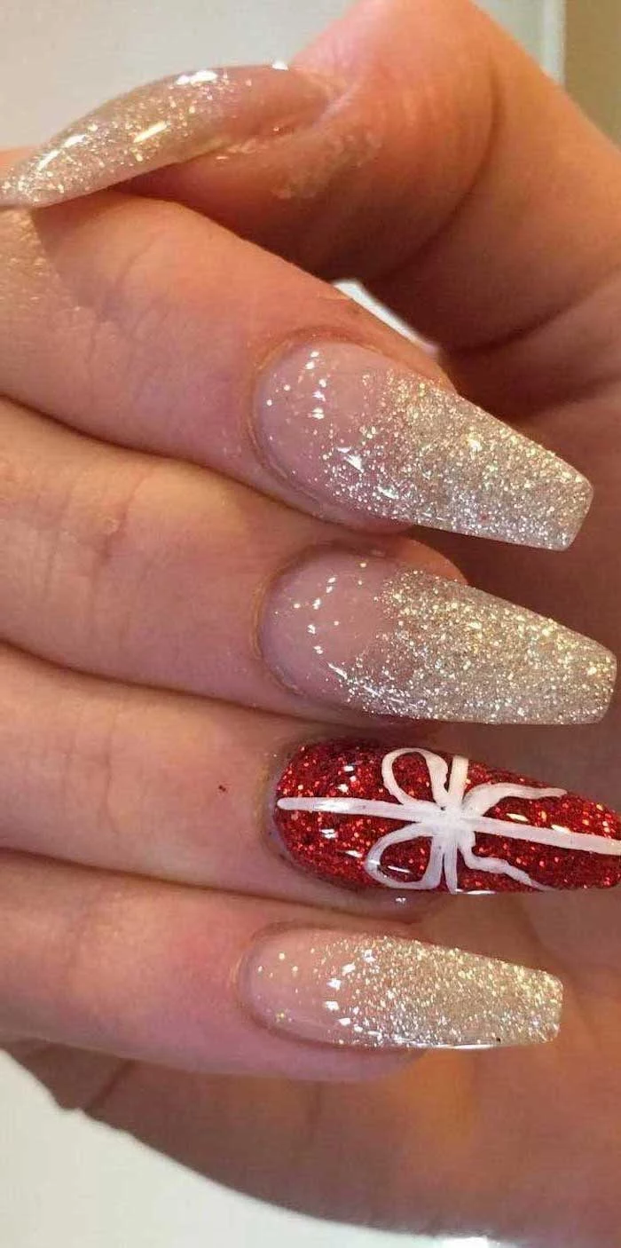 gold and red glitter nail polish, trending nail colors, long coffin nails, white bow decoration on the ring finger
