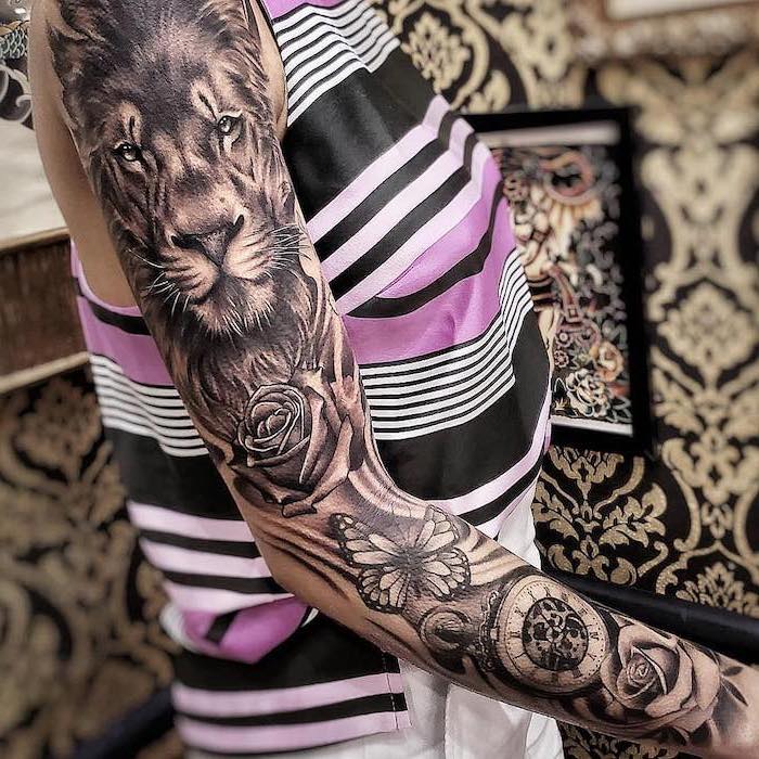 sleeve tattoo on woman wearing top in pink black and white, lion tattoos for females, lion with roses butterflies and watch