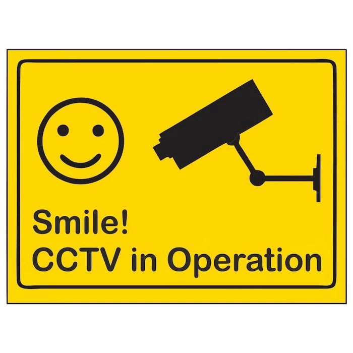 smile cctv in operation sign, target for burglars, smiley face and camera on yellow background