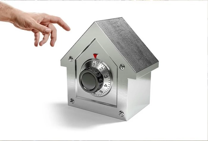 steel safe in the shape of a house, target for burglars, placed on white surface