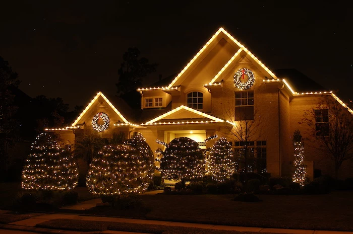 large two storey house, decorated with lights, outside christmas decoration ideas, all the bushes in the yard, decorated with lights