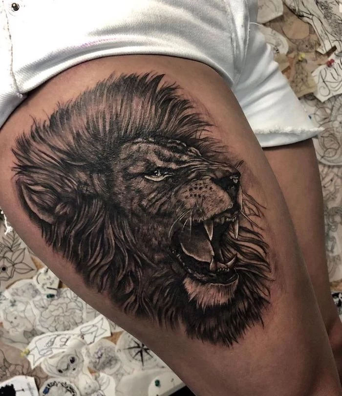 thigh tattoo, profile of a roaring line with large mane, on woman wearing white short jeans, small lion tattoo