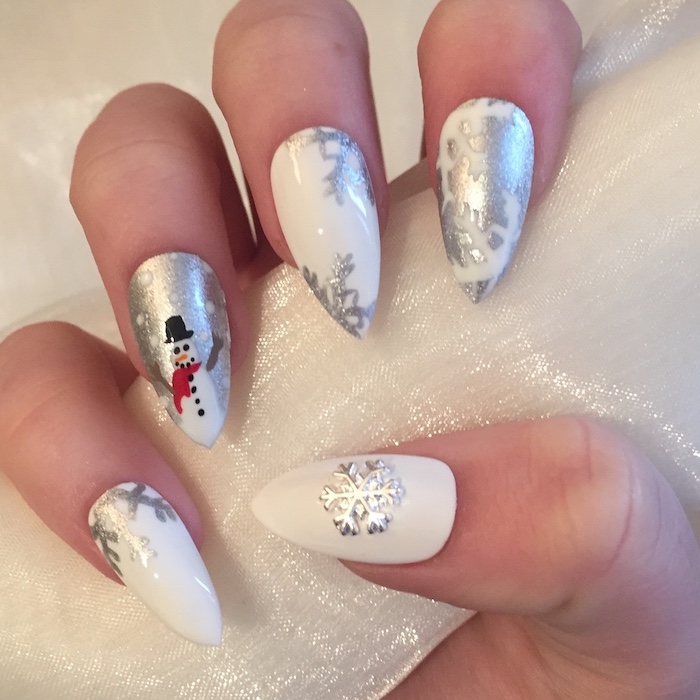 white and silver metallic nail polish, winter acrylic nails, long stiletto nails, snowflakes and snowman decorations on each nail