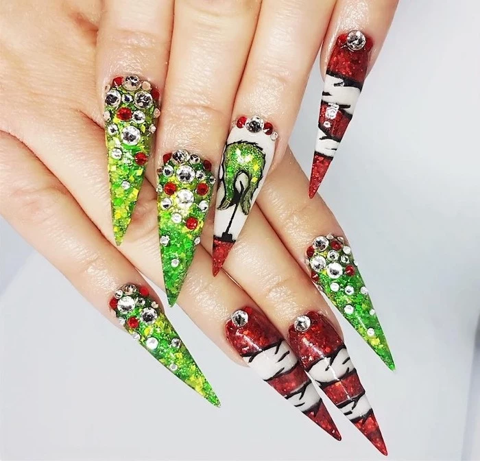 grinch themed decorations on each nail, winter acrylic nails, red and green glitter nail polish, decorations with rhinestones