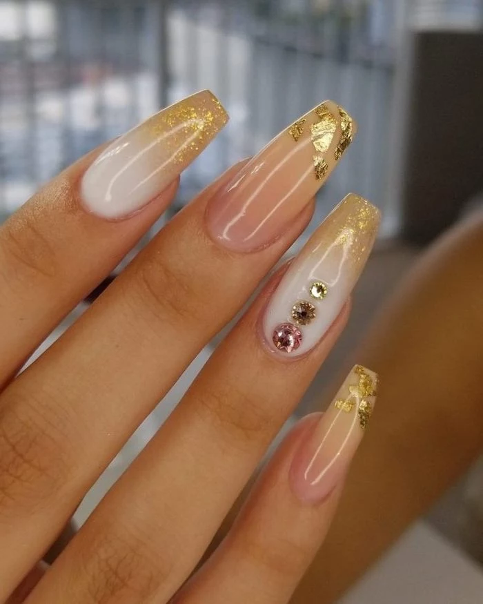 glitter ombre nails, long coffin nails, white to gold glitter gradient nail polish, rhinestones decorations on the ring finger