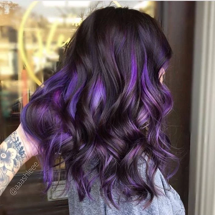 black hair with purple highlights, blonde hair color ideas, shoulder length wavy hair, woman wearing grey blouse