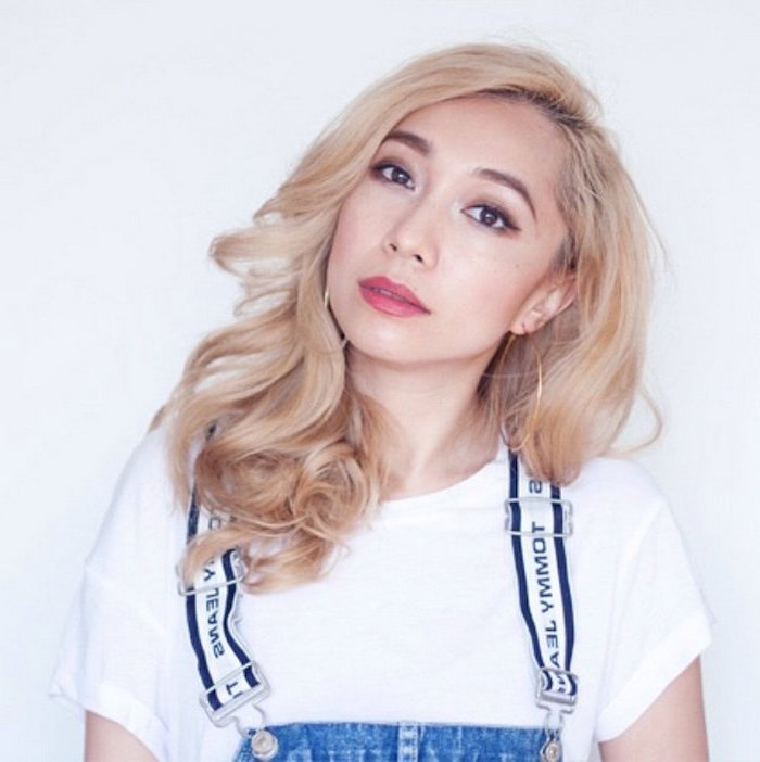 woman wearing white t shirt and denim overalls, blonde hair color ideas, shoulder length wavy blonde hair