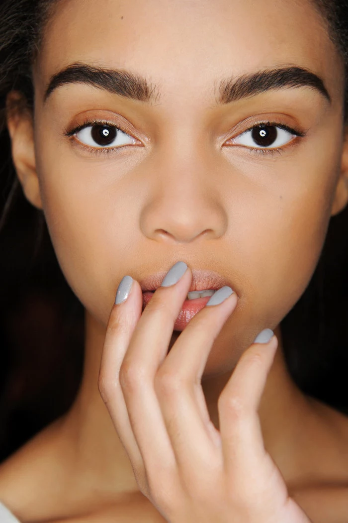 woman with dark eyes and hair, grey nail polish, short squoval nails, cute winter nails