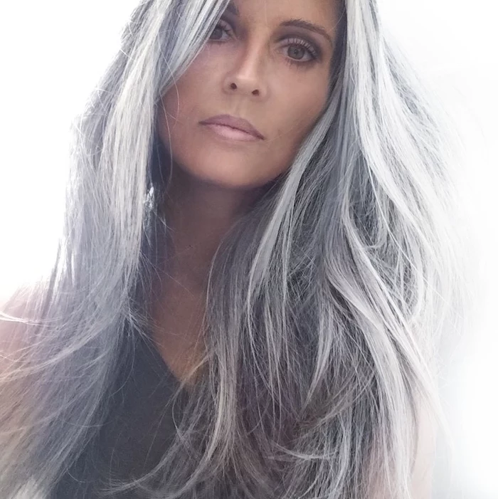 woman wearing black top, natural grey hair, long wavy hair, purple highlights in brown hair