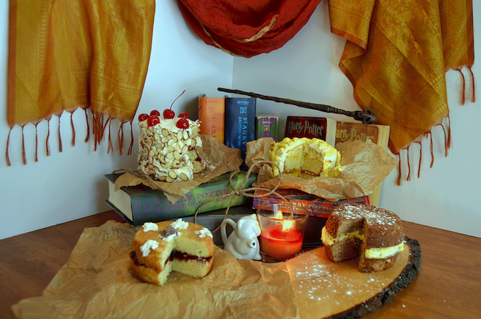 two hagrid's rock cakes, placed on wooden boards, harry potter cake ideas, harry potter books arranged behind them