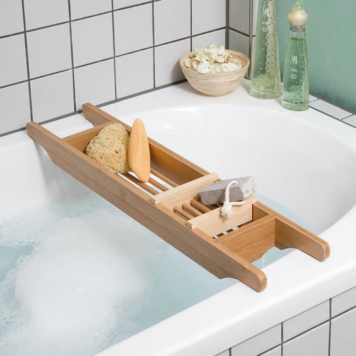 wooden bath tray, placed over a white bath with tiles, valentine gift ideas, bottles of aroma oils on the side