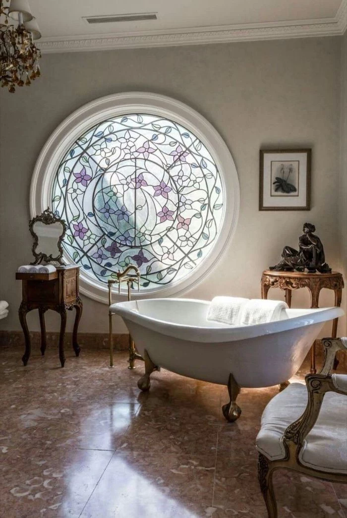 stained glass panels, bathroom with vintage bath, brown tiled floor, round window, decorated with flowers