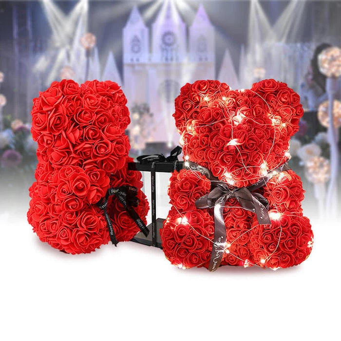 two bears made of red roses, wrapped with black satin bows and fairy lights, valentines decoration ideas, placed on white surface