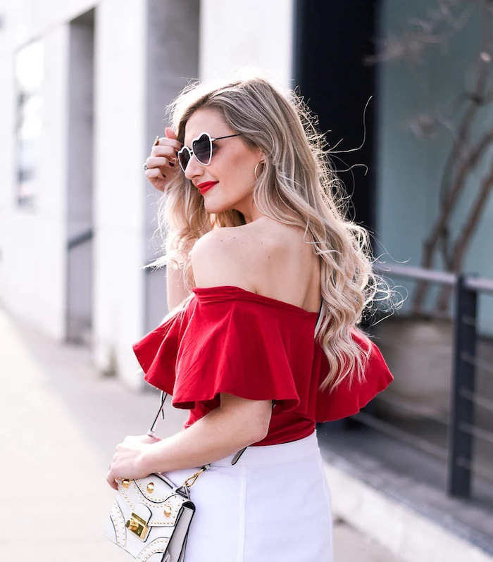 blonde woman wearing red open shoulder crop top, white short skirt, valentines day dresses, heart shaped glasses