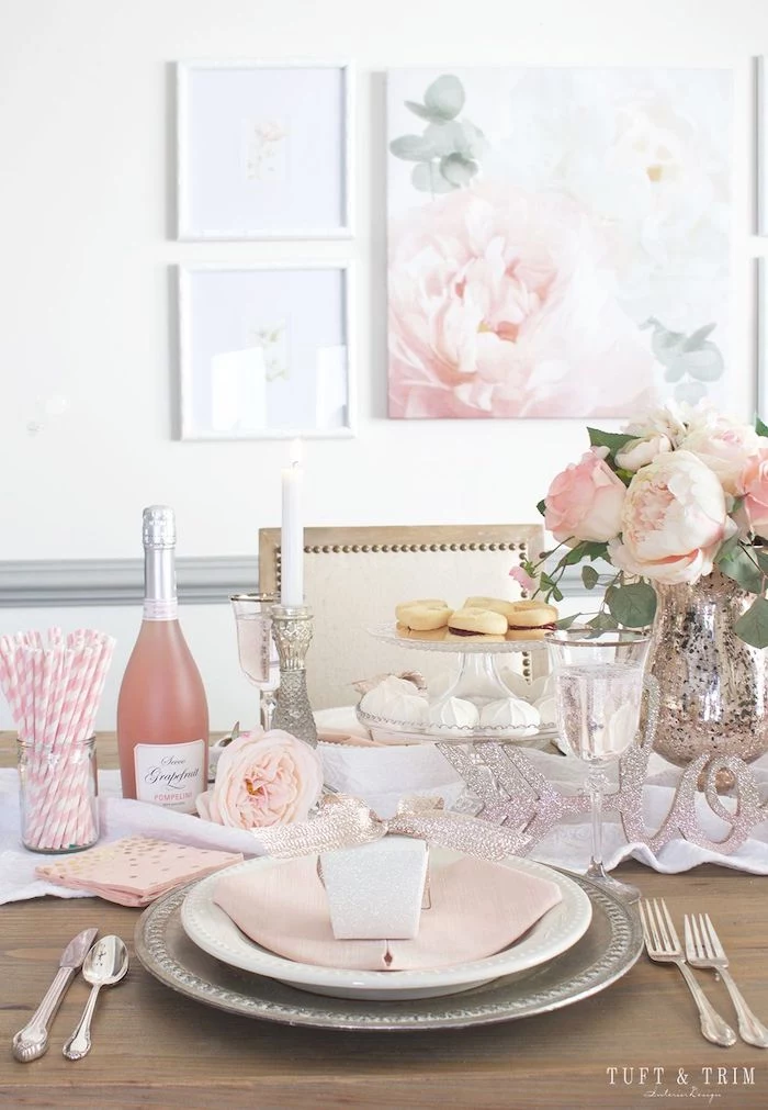 valentine's day decoration ideas, dinner table set for two, peony flower bouquet in the middle, cake stand and champagne