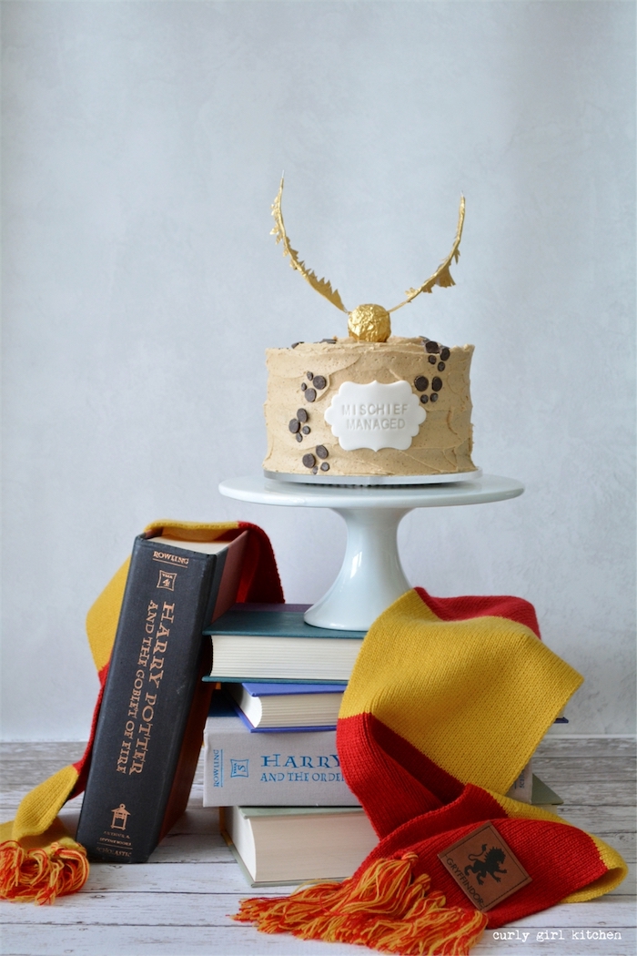 happee birthdae, one tier cake covered with buttercream, mischief managed, placed on cake stand on top of books