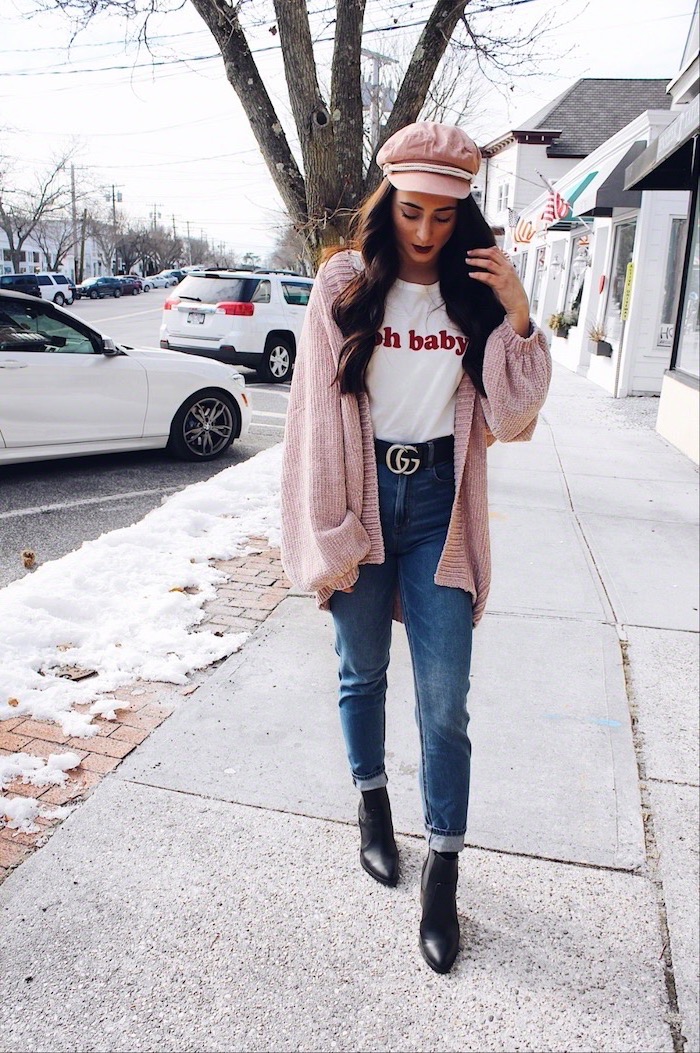 woman walking on side walk, wearing jeans and white t shirt, red dress for valentine's day, pink cardigan and hat
