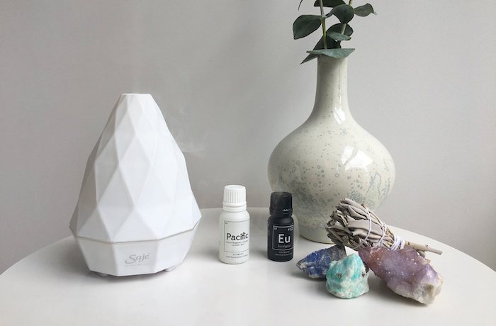 romantic gifts for her, essential oil diffuser, essential oil bottle, vase and stones placed on white table, white background
