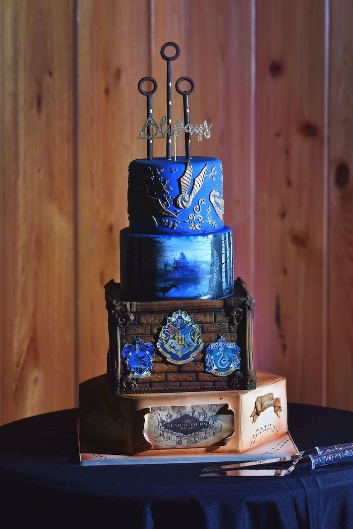 four tier cake, each layer with different image, hagrid birthday cake, ravenclaw inspired cake, marauder's map on bottom layer