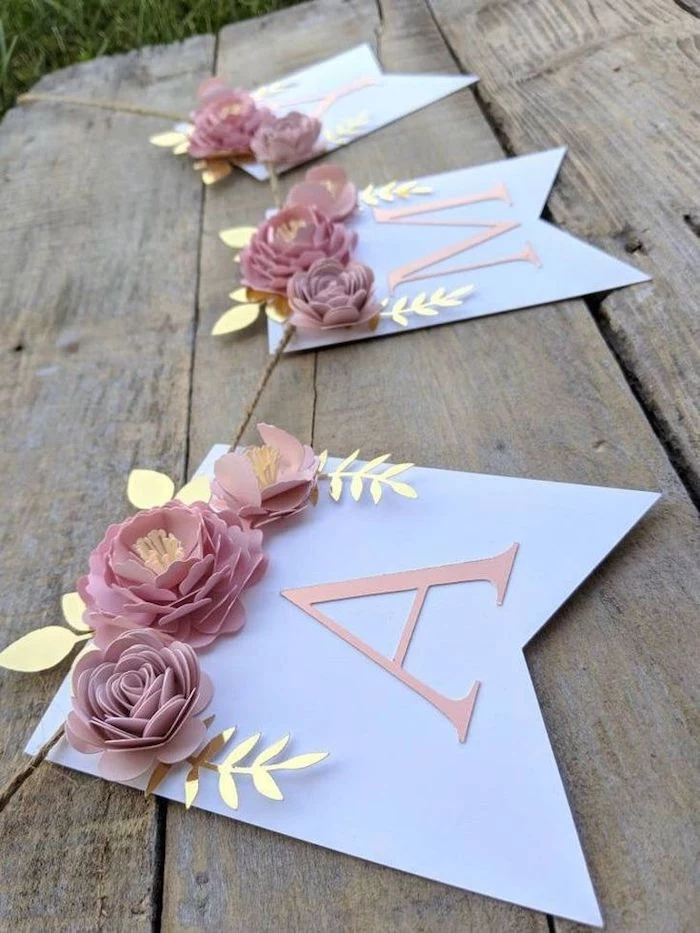 paper garland made with pink paper flowers, paper flower backdrop, placed on a wooden surface