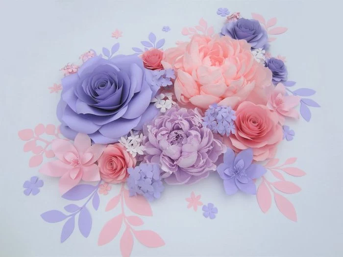 giant paper flowers, purple blue and blush paper flowers, arranged together on white surface, different shapes and sizes