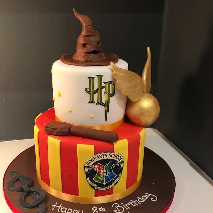 hagrid cake, two tier gryffindor cake, made with red and yellow fondant, sorting hat and golden snitch toppers