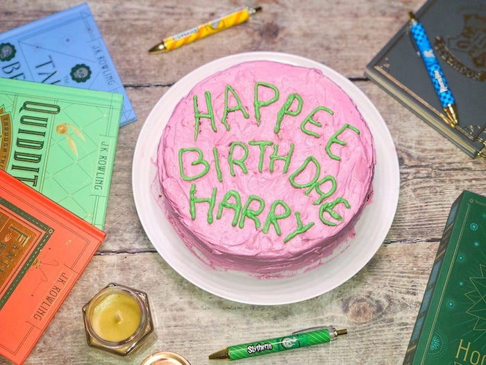 happee birthdae harry cake, covered with pink and green buttercream, hagrid cake, placed on wooden table