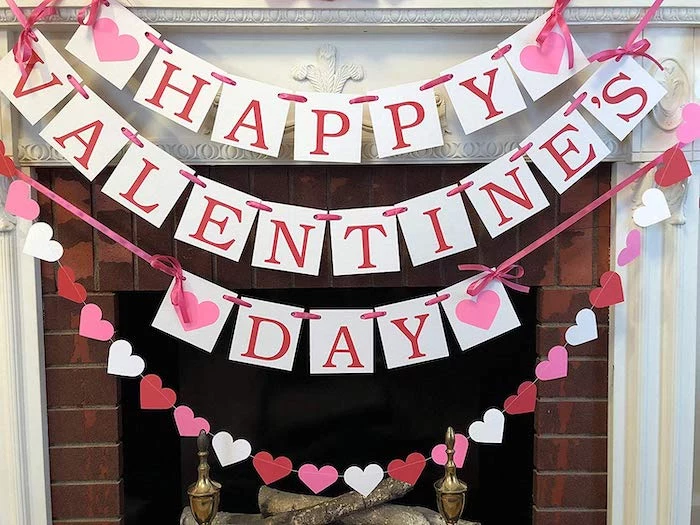 happy valentine's day banner, hearts garland hanging over mantel, tied with pink bows, valentines day decor ideas