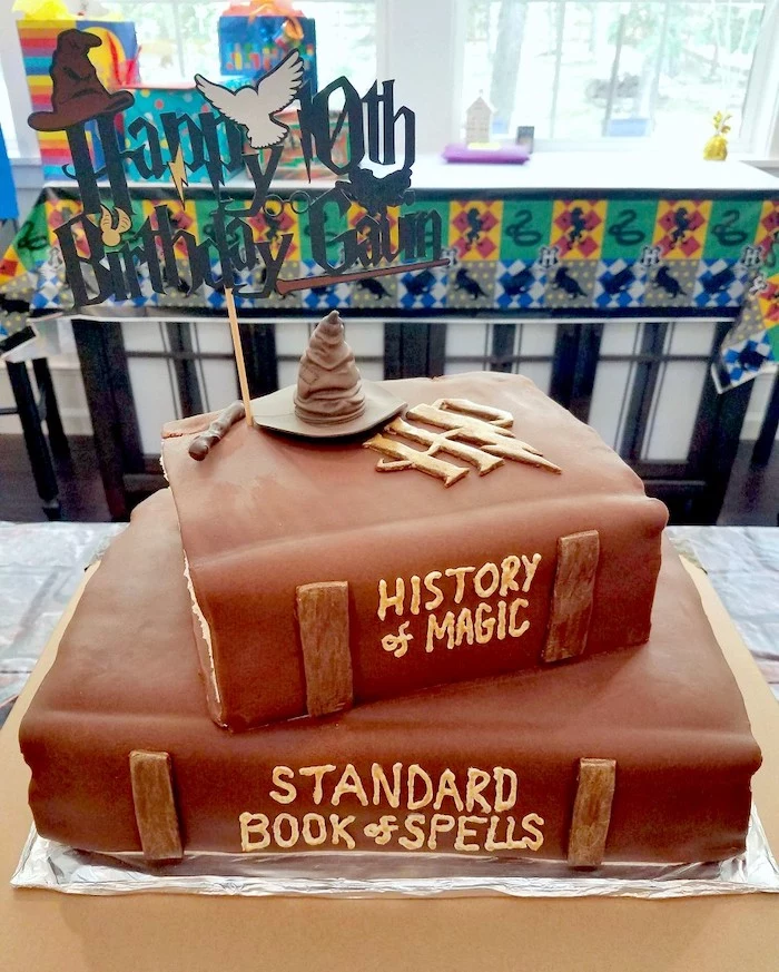 two tier cake in the shape of books, harry potters birthday cake, history of magic, standard book of spells