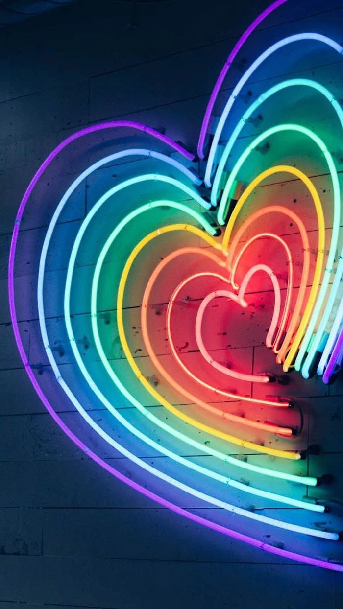 heart shaped neon lights, in the colors of the rainbow, cute aesthetic backgrounds, hanging on wooden wall
