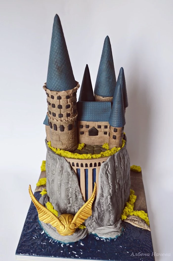 two tier hogwarts cake, harry potters birthday cake, golden snitch on the side, made with fondant, white background