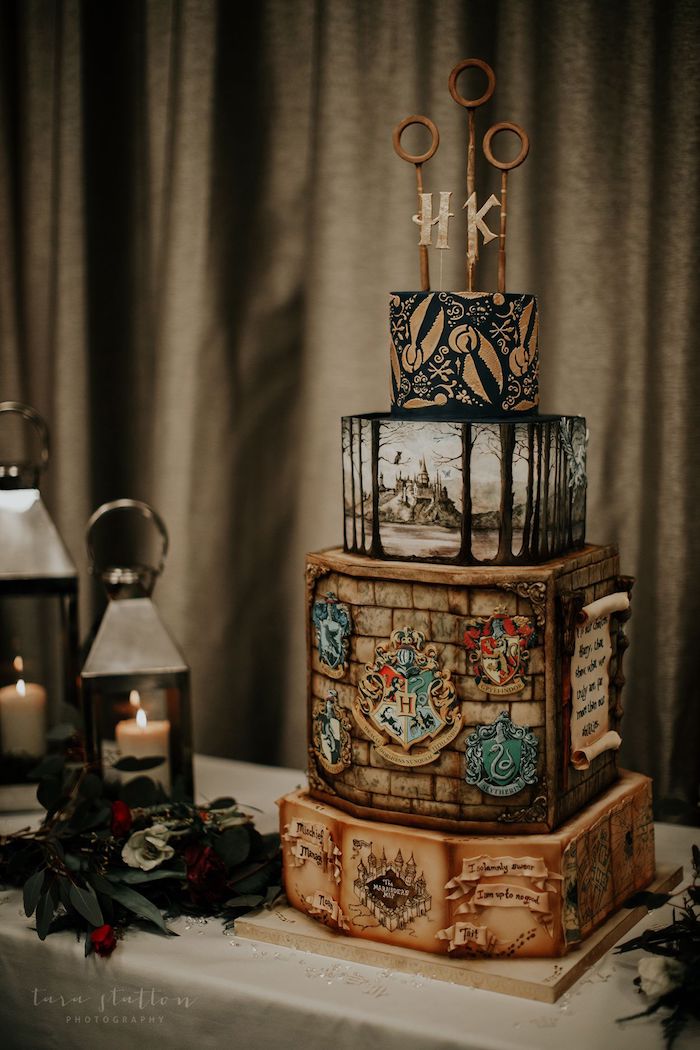 four tier cake, marauder's map on bottom tier, three quidditch hoops topper, harry potters birthday cake