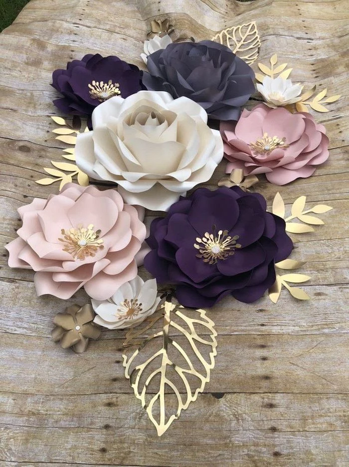 large white blush and purple paper flowers, different shapes and sizes, paper flower decorations, placed on wooden surface