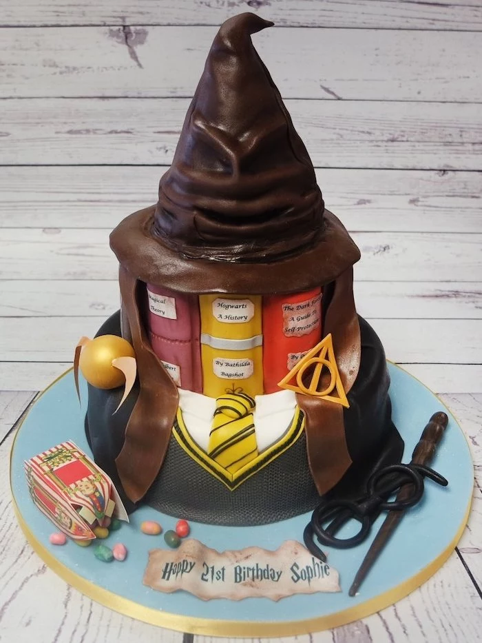 two tier cake, hufflepuff unidorm bottom tier, vooks second tier, sorting hat made of fondant on top, harrys birthday cake