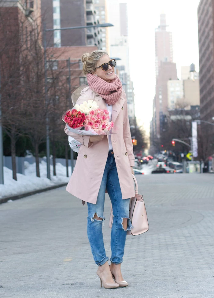 woman holding bouquet of roses, date outfit ideas, wearing jeans and white shirt, pink coat and scarf, nude shoes and bag