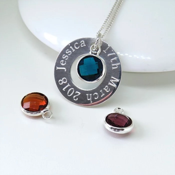 personalised silver necklace with birthstone in the middle, best valentines gifts for her, placed on white surface