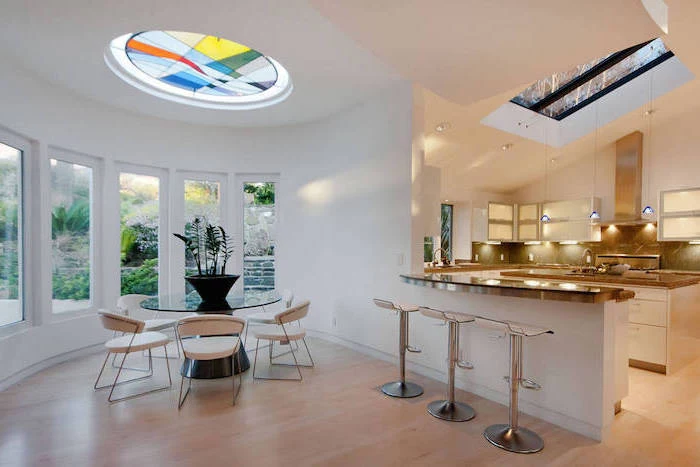ceiling window decorated with colored glass, stained glass doors, dining room with glass round table, white chairs