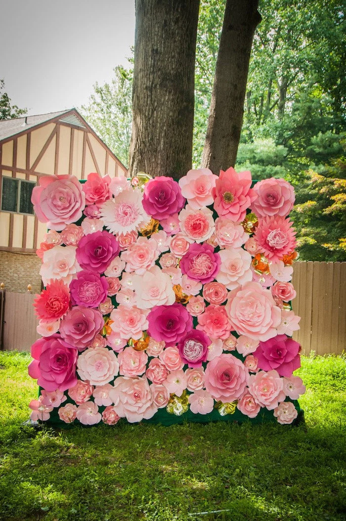 pink and blush paper flowers, arranged together as a backdrop, paper flower wall decor, placed on the ground