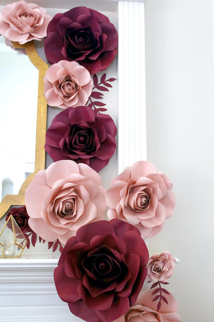 how to make flowers out of tissue paper, blush and pink paper flowers, arranged around a mirror, hanging on a white wall