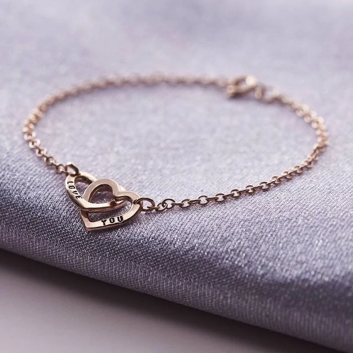 cute valentines day gifts for her, love you personalised bracelet, two connected hearts, placed on grey surface
