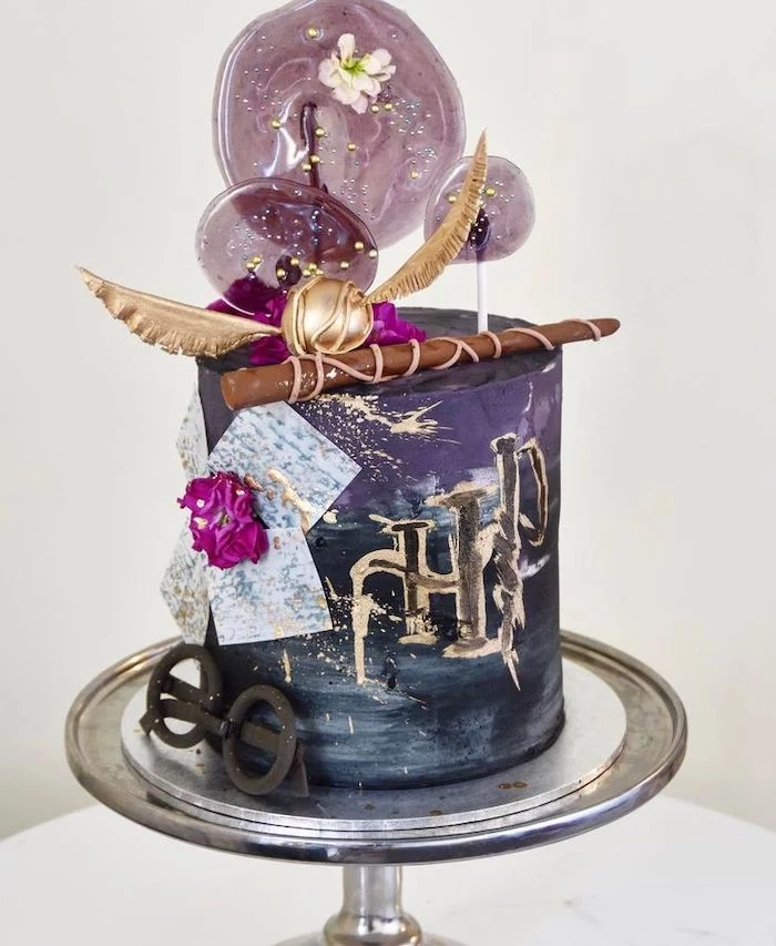 one tier cake, covered with black and purple fondant, hogwarts cake, golden snitch and wand on top
