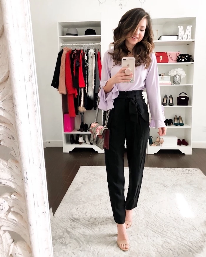 woman taking a selfie in the mirror, wearing black pants, purple blouse, valentine's day clothes, nude sandals
