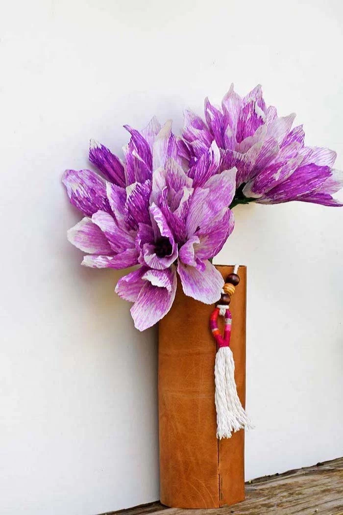 purple and white flowers, made of crepe paper, placed in a leather boho vase, diy paper flowers